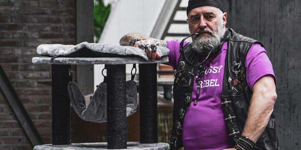 man in purple long sleeve shirt holding white plastic bag