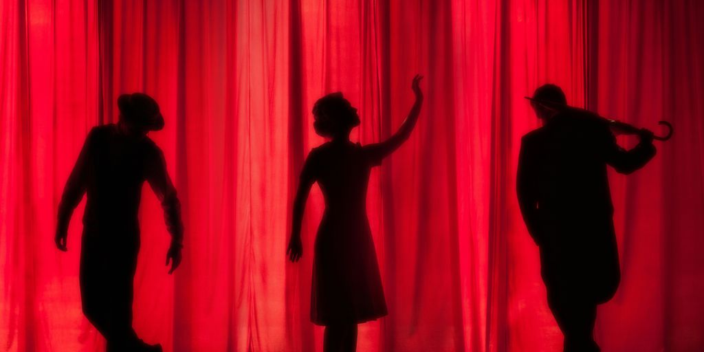 silhouette of three performers on stage