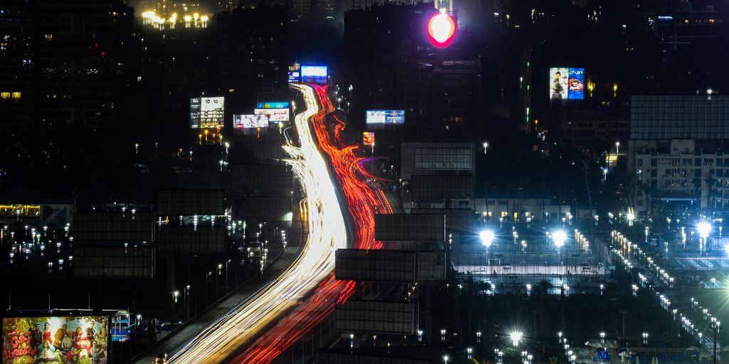 a city street at night with a red traffic light