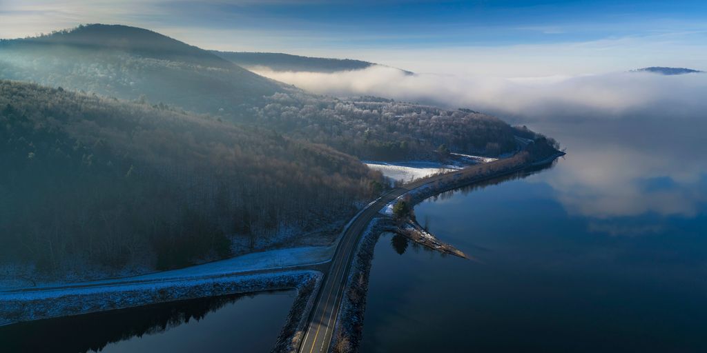 an aerial view of a road near a body of water