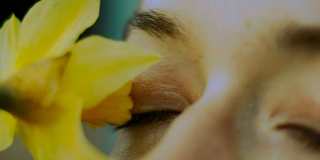 a close up of a person holding a flower