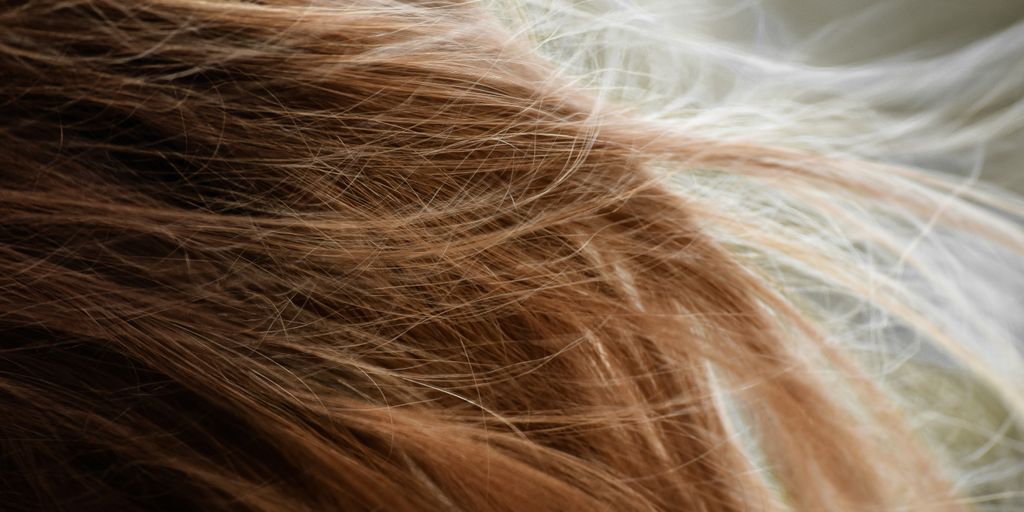 brown hair on white textile