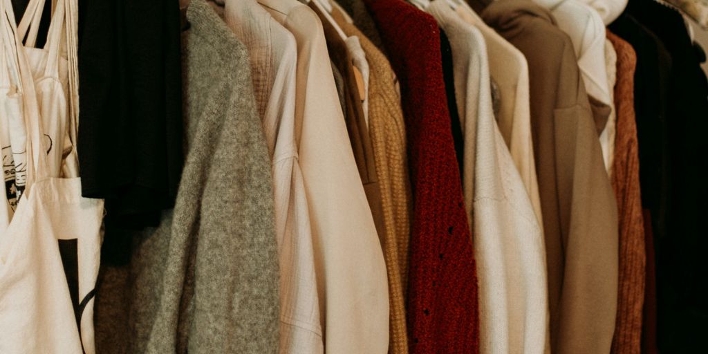 brown and white coat hanged on rack