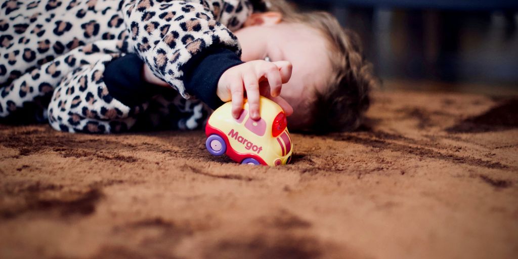 baby playing yellow toy car