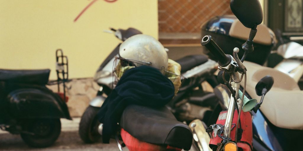 a red scooter parked next to a yellow building