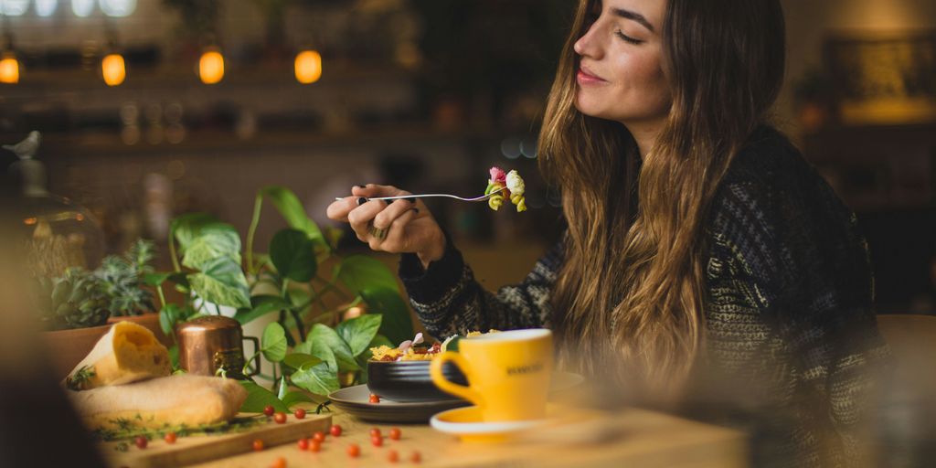 woman holding fork in front table