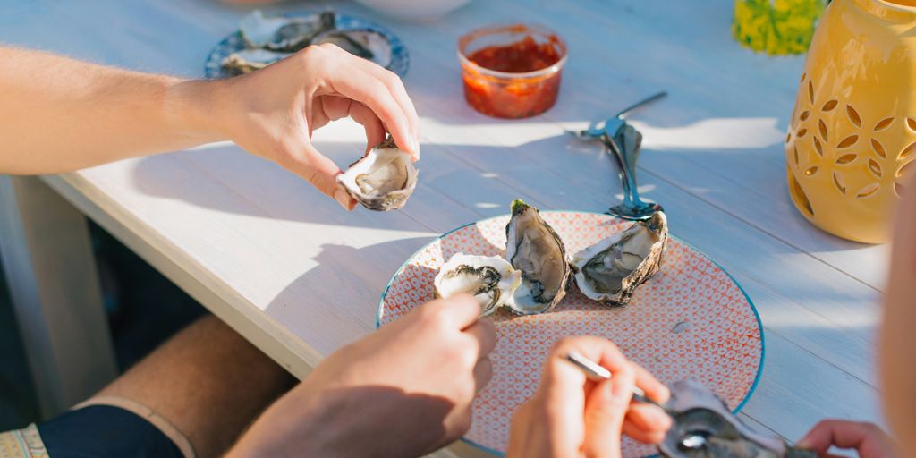 person holding a silver fish on a table