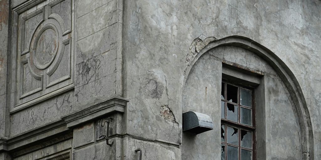 an old building with a broken window and a clock