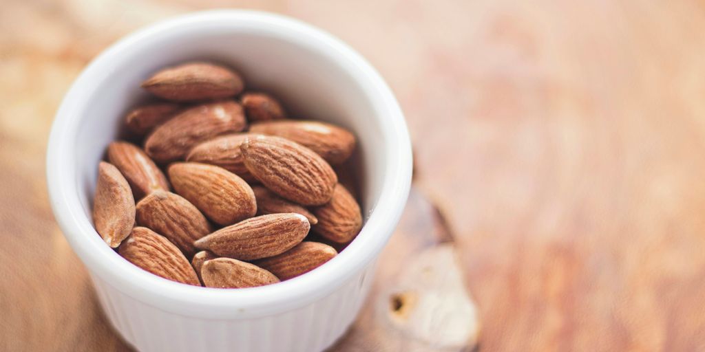 shallow focus photography of almonds in white ceramic bowl