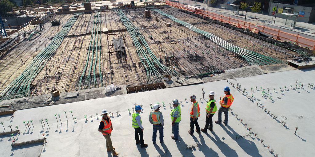 seven construction workers standing on white field