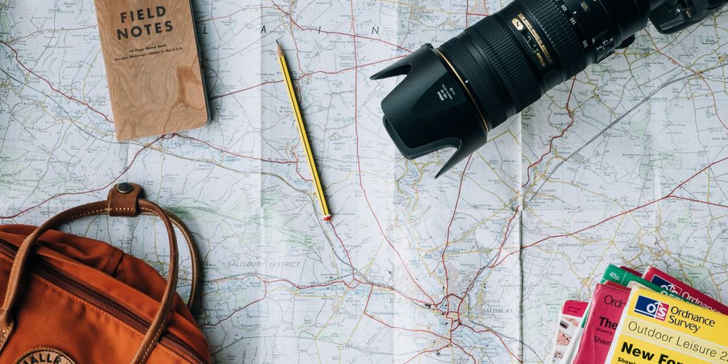 flat lay photography of camera, book, and bag