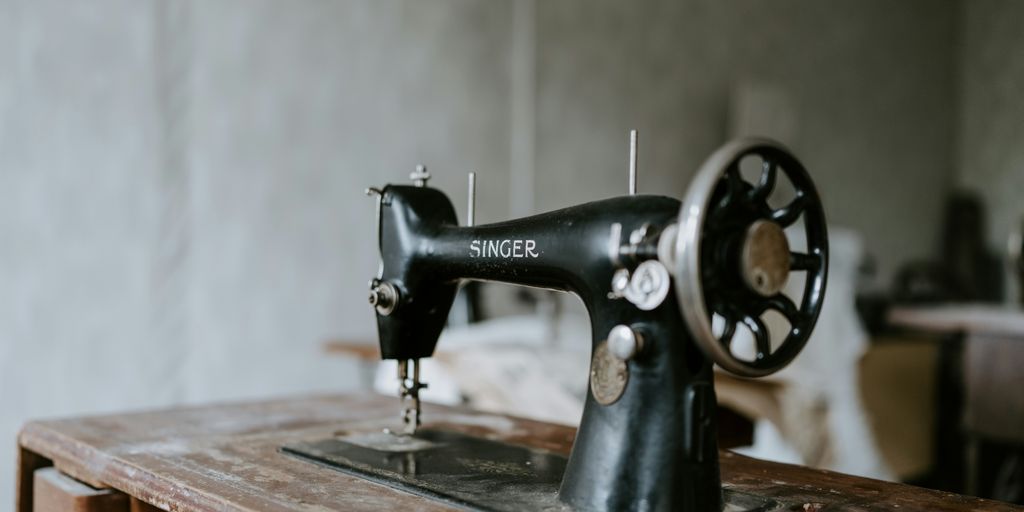 black sewing machine on brown wooden table